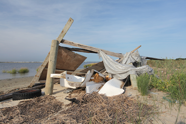 A beach shelter built from salvaged garbage and tarps.