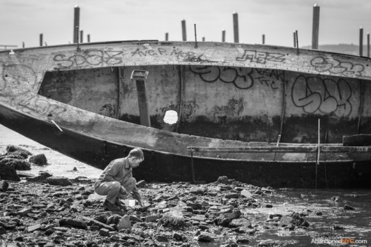 A local man hunts for crabs under the rocks.